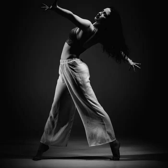 Dançarina em movimento expressivo sob luz de palco